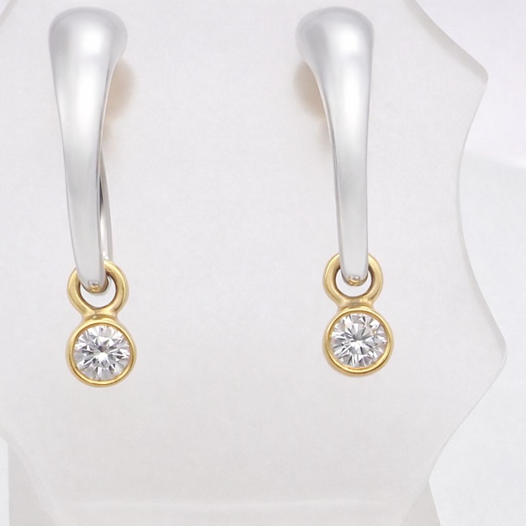 An unusual pair of earrings. The design like a French horn is fashioned in 18 carat gold, measures 18x 10mm.