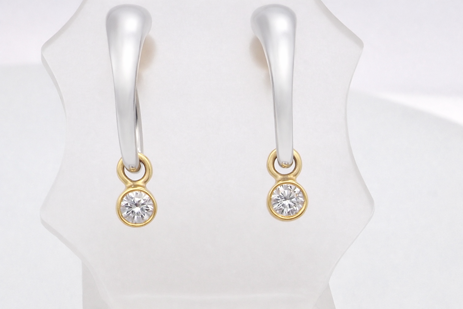 An unusual pair of earrings. The design like a French horn is fashioned in 18 carat gold, measures 18x 10mm.