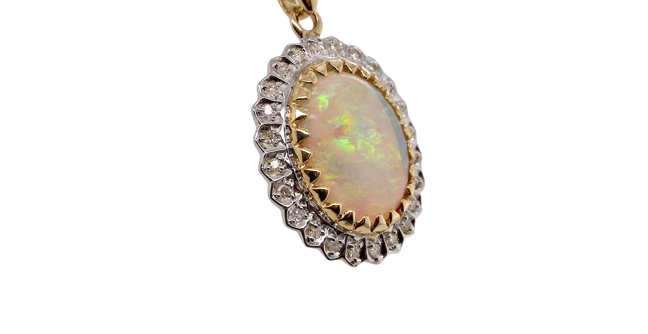Opal pendant with diamond accents on a gold chain against a white background
