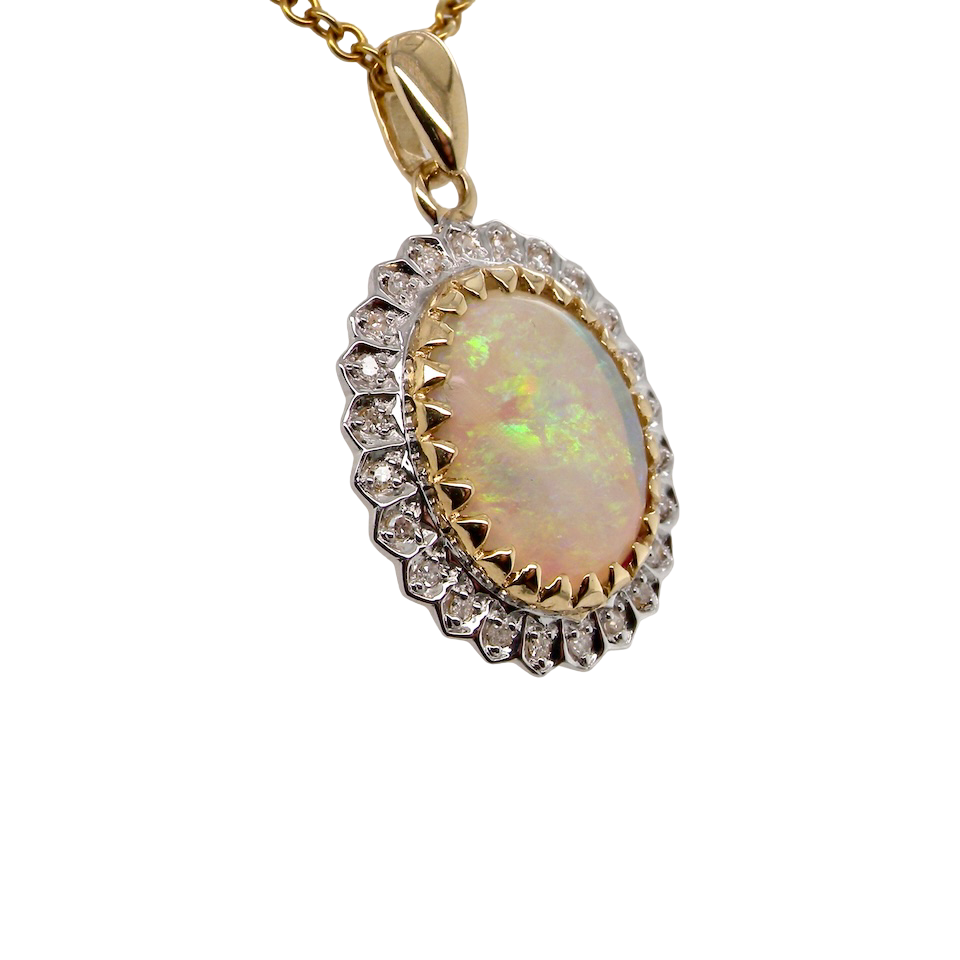 Opal pendant with diamond accents on a gold chain against a white background