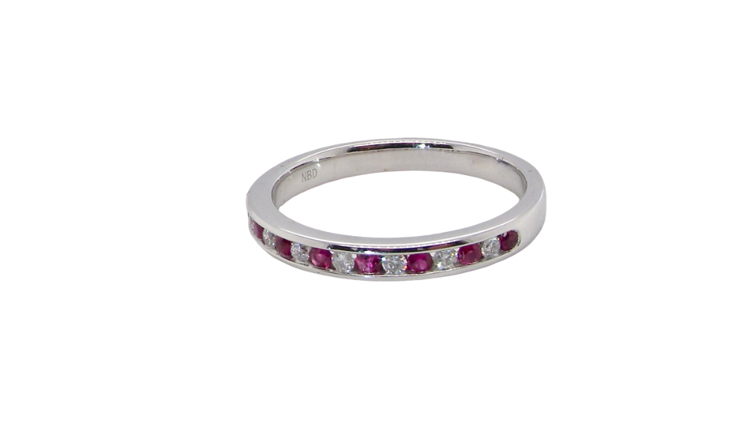 A white gold half hoop eternity ring. Set with seven round rubies and six brilliant cut white diamonds