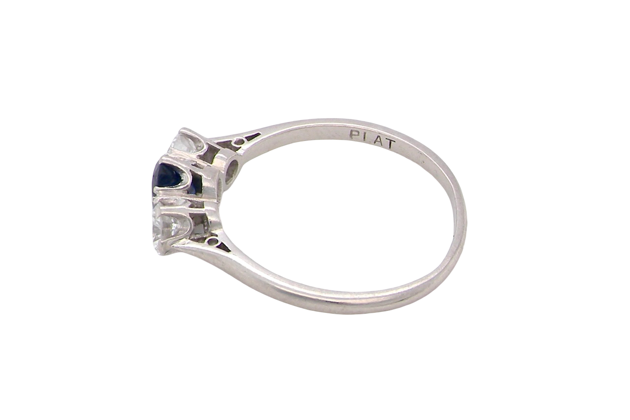 side classic trilogy ring set with an exquisite oval cut sapphire centre stone, hues of deep blue colour and measuring 6x4.2mm (est approx 0.50 carats)