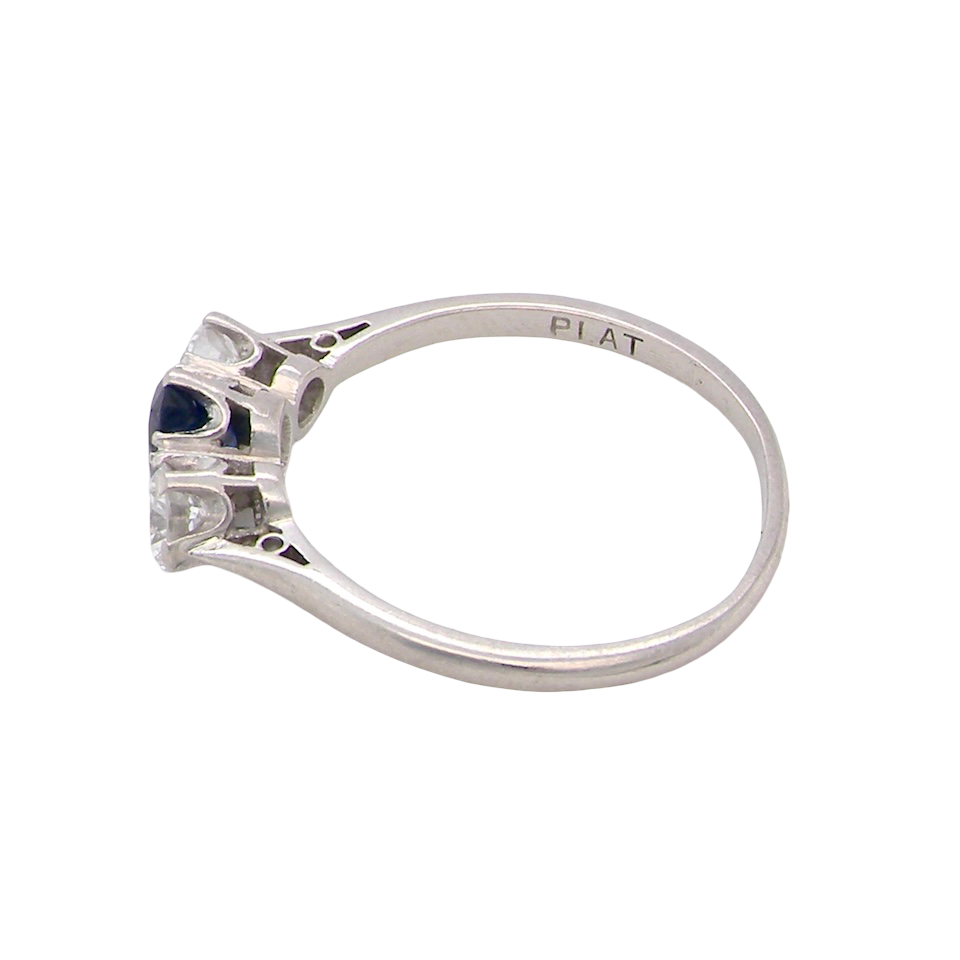 side classic trilogy ring set with an exquisite oval cut sapphire centre stone, hues of deep blue colour and measuring 6x4.2mm (est approx 0.50 carats)