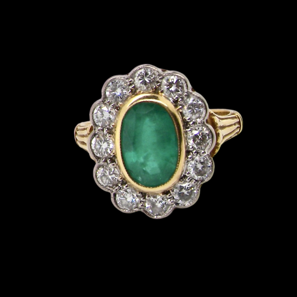 An impressive Emerald and Diamond cluster Ring