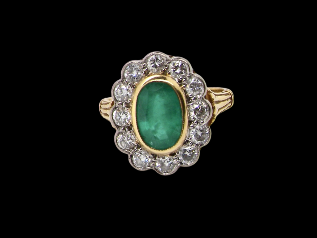 An impressive Emerald and Diamond cluster Ring