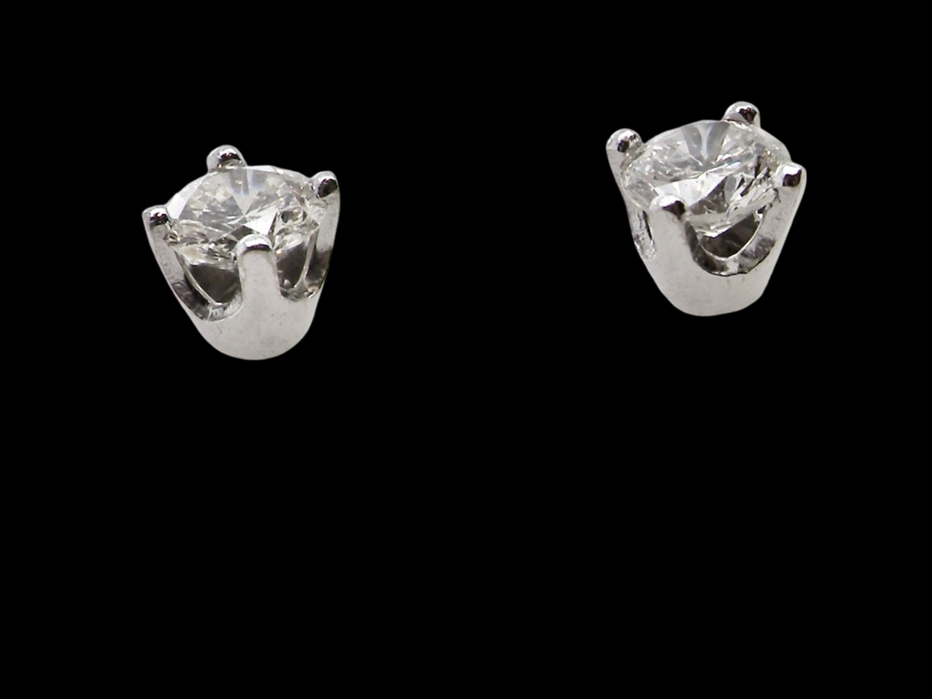 A pair of diamond stud earrings side view