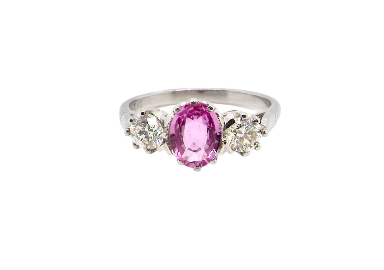 A platinum three stone pink sapphire and diamond ring