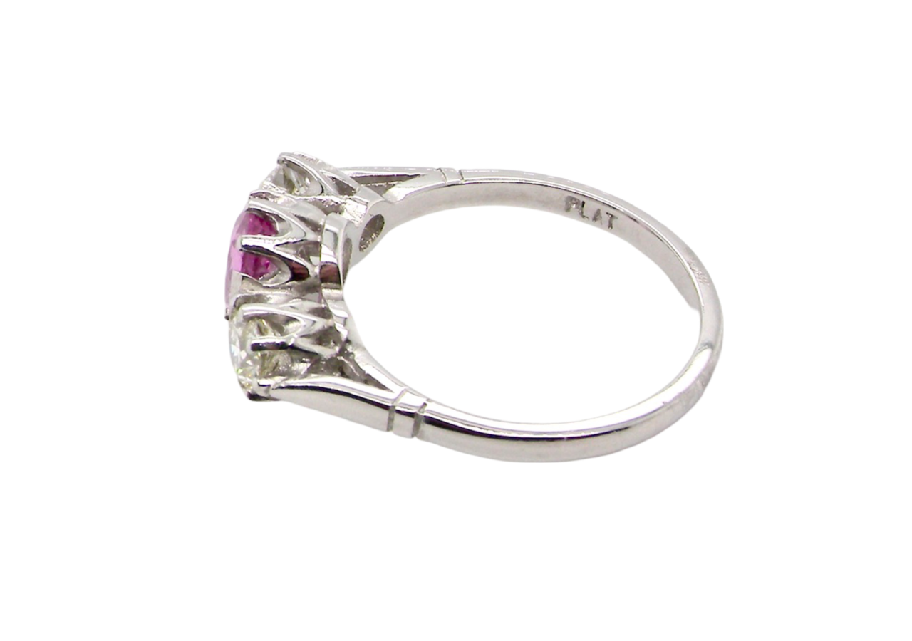 A platinum three stone pink sapphire and diamond ring side view