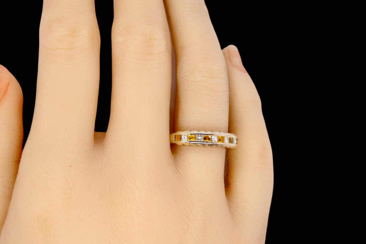 A yellow sapphire and diamond eternity ring finger view