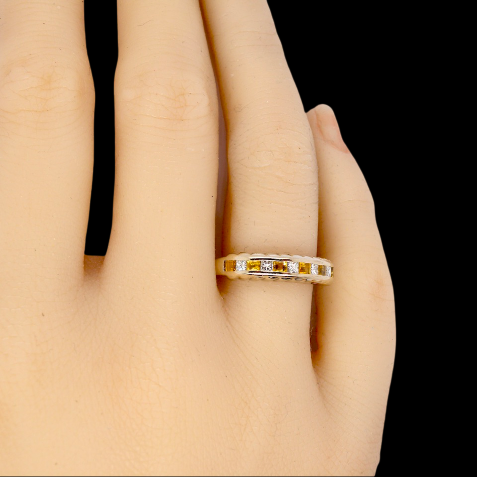 A yellow sapphire and diamond eternity ring finger view