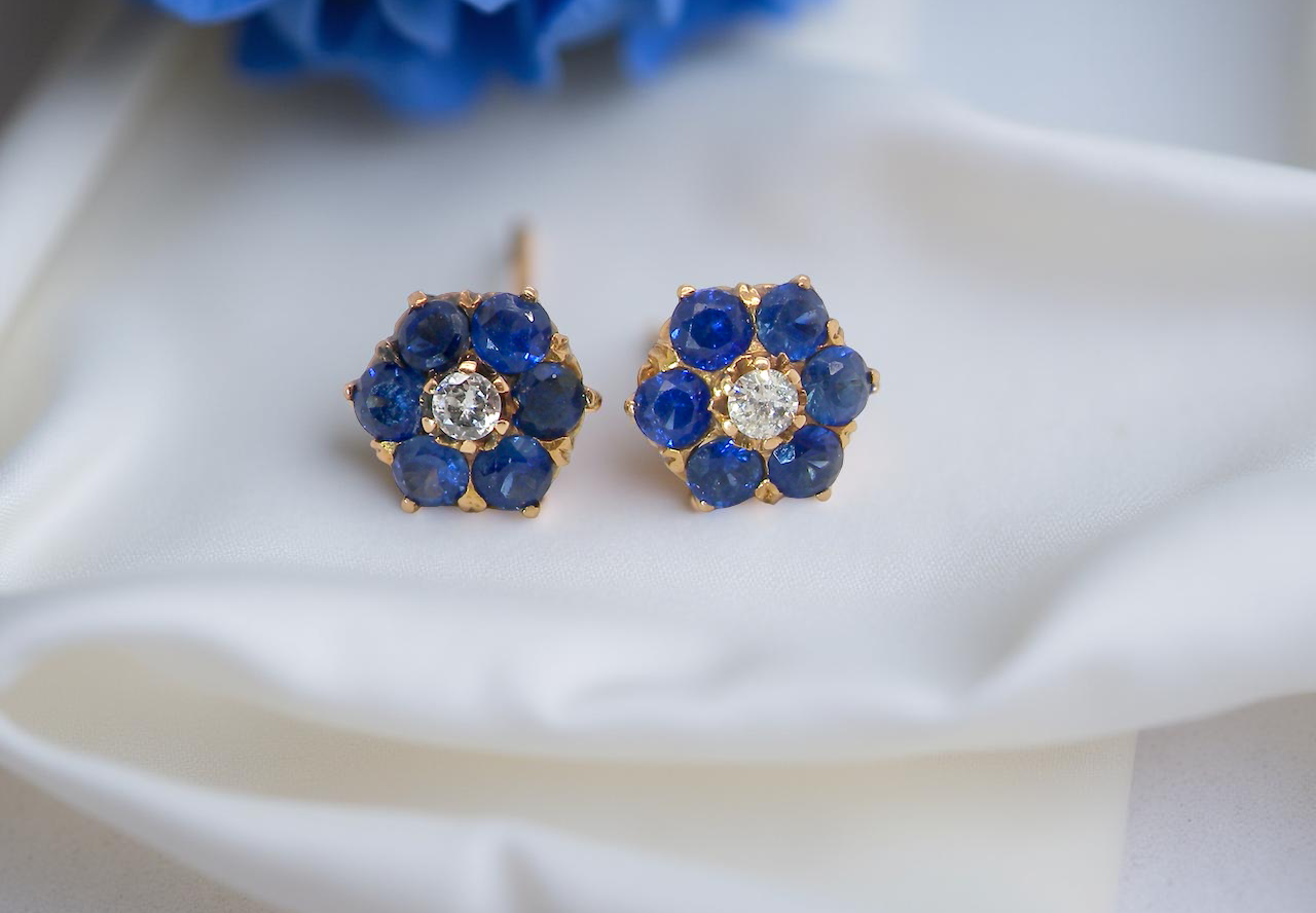 Pair of blue gemstone earrings with gold accents on a white surface.