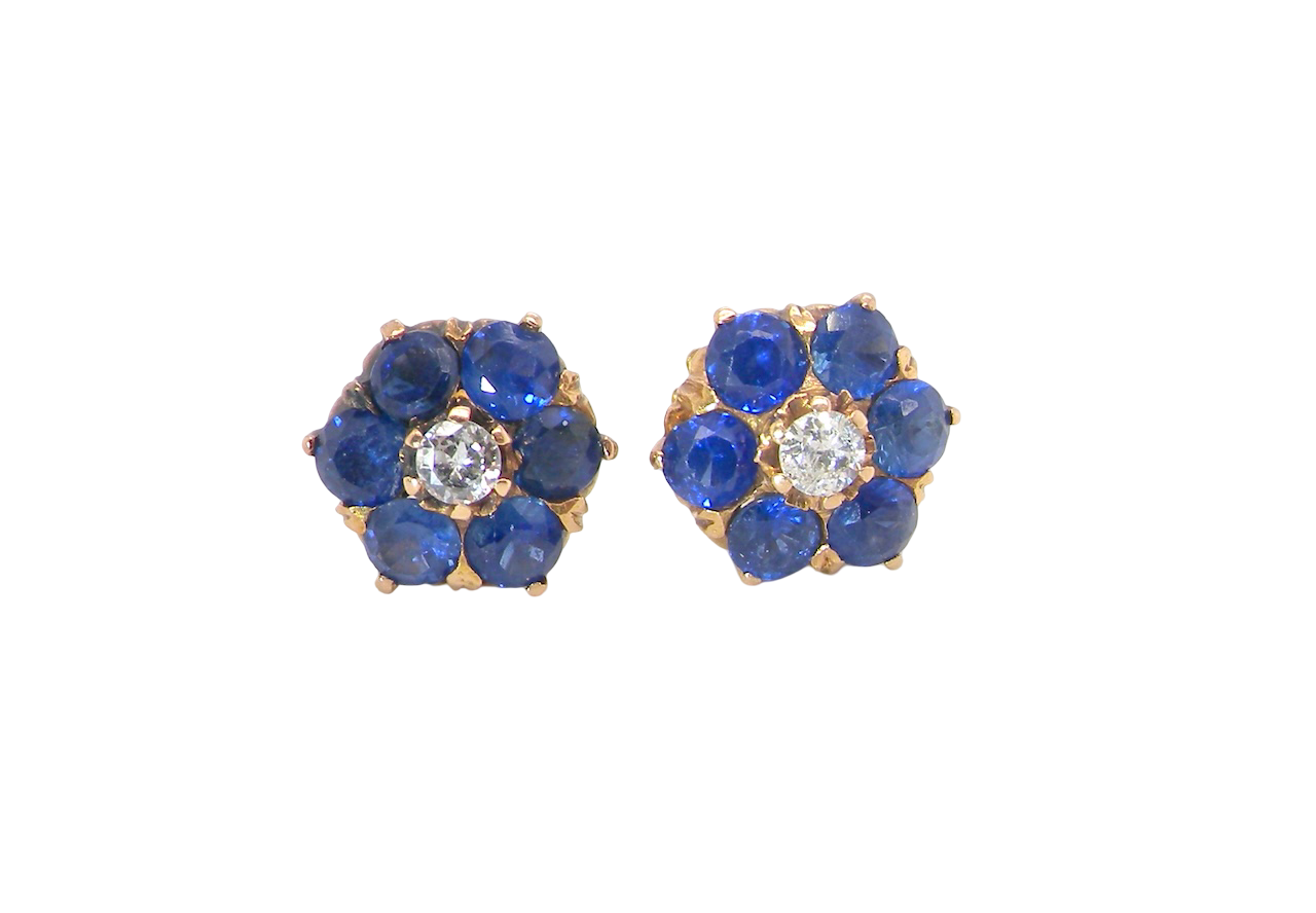 Pair of earrings with blue gemstones and a central diamond on a white background