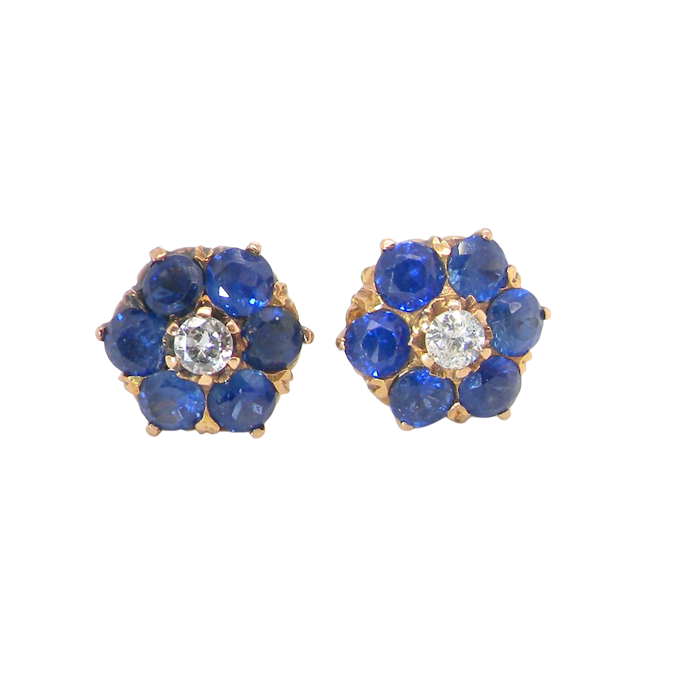 Pair of earrings with blue gemstones and a central diamond on a white background