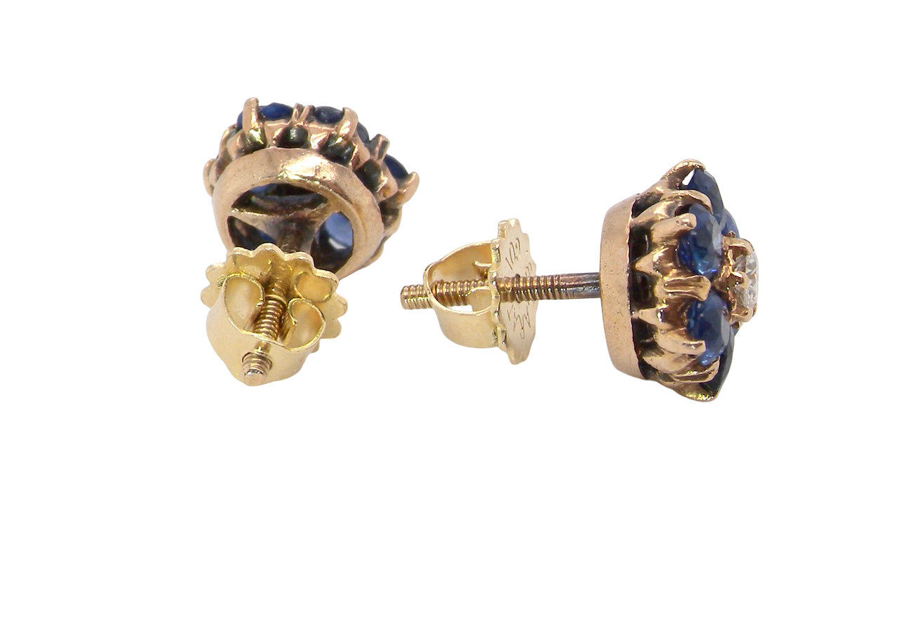 Gold earrings with blue gemstones on a white background