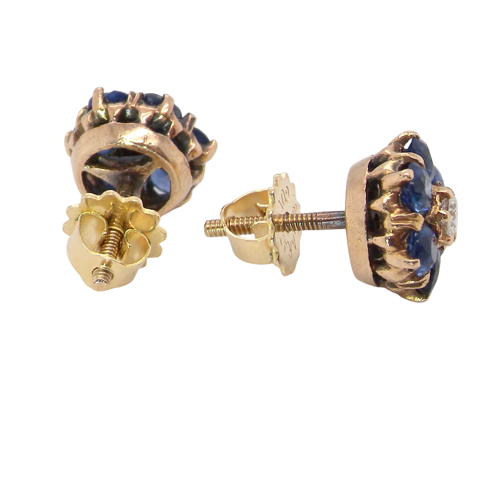 Gold earrings with blue gemstones on a white background