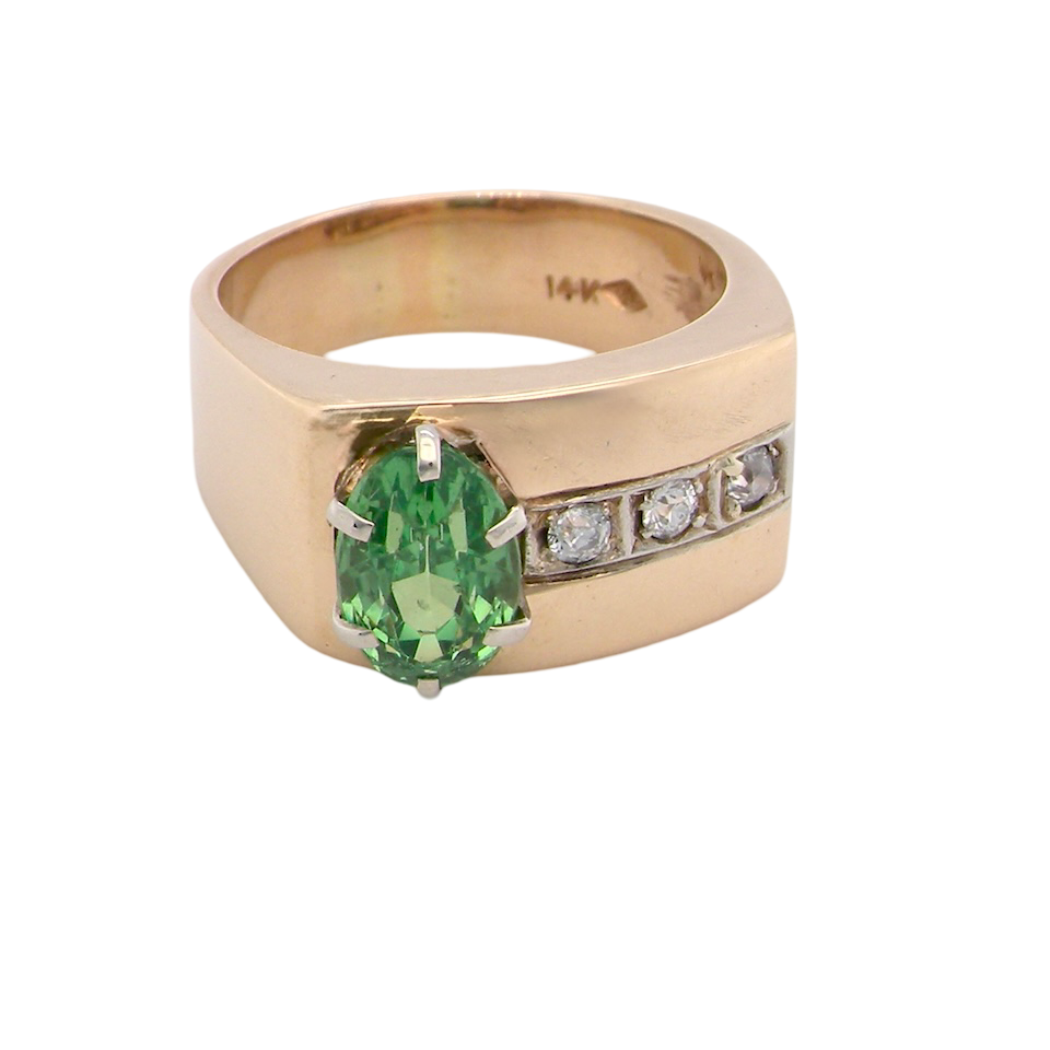 An image of a 14 carat gold dress ring set with an oval green tsavorite garnet and three small brilliant cut white diamonds