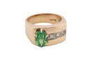 An image of a 14 carat gold dress ring set with an oval green tsavorite garnet and three small brilliant cut white diamonds