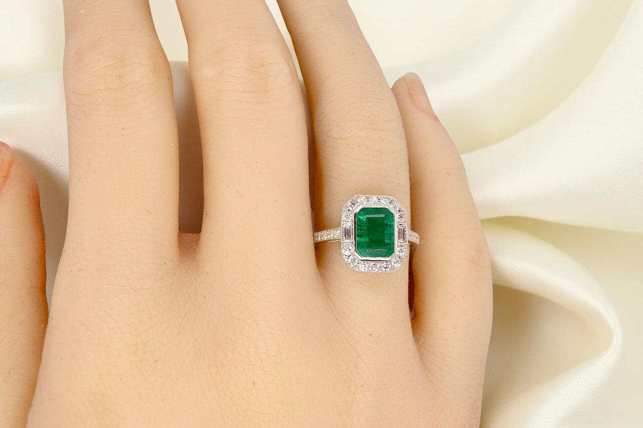 Emerald ring on a hand with a soft white background