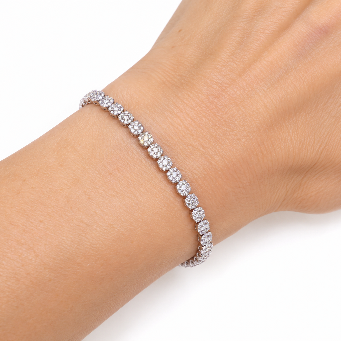 tennis bracelet with round-cut clear stones, shown worn on a person's wrist against a plain white background.