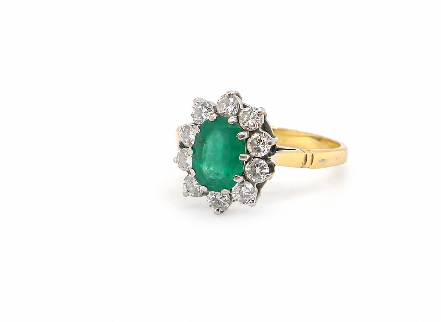 Features an oval cut emerald centre stone, vibrant green hues, measures 9x6mm(est 1.75 carats) . Complimented by an outer halo of ten 2.7mm brilliant cut white diamonds (