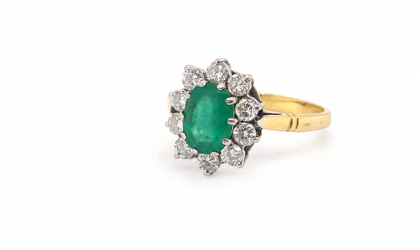 Features an oval cut emerald centre stone, vibrant green hues, measures 9x6mm(est 1.75 carats) . Complimented by an outer halo of ten 2.7mm brilliant cut white diamonds (
