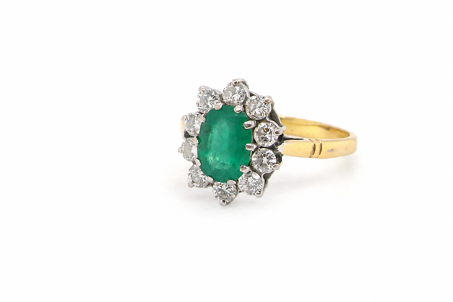 Features an oval cut emerald centre stone, vibrant green hues, measures 9x6mm(est 1.75 carats) . Complimented by an outer halo of ten 2.7mm brilliant cut white diamonds (