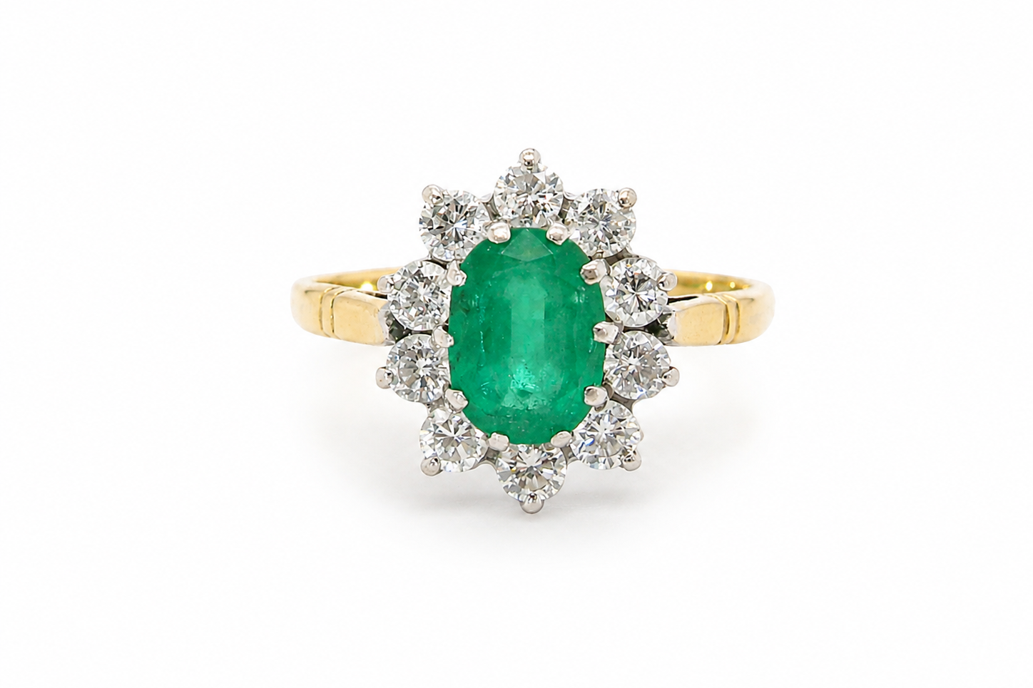 Features an oval cut emerald centre stone, vibrant green hues, measures 9x6mm(est 1.75 carats) . Complimented by an outer halo of ten 2.7mm brilliant cut white diamonds (est total 0.60 carats)