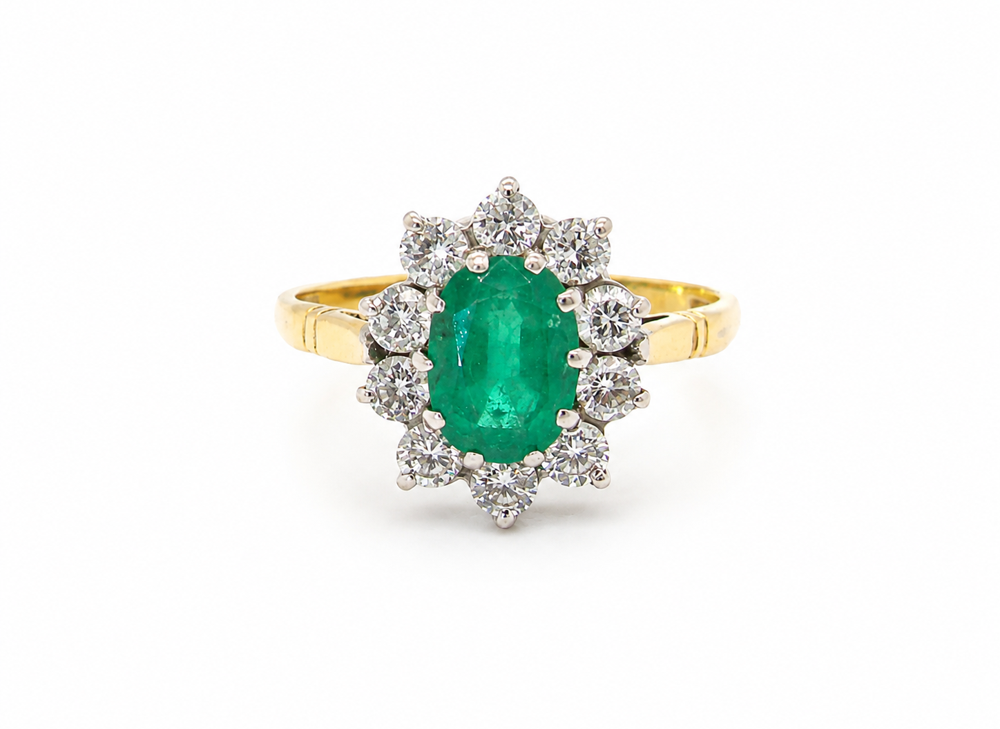 Features an oval cut emerald centre stone, vibrant green hues, measures 9x6mm(est 1.75 carats) . Complimented by an outer halo of ten 2.7mm brilliant cut white diamonds (est total 0.60 carats) colour i-j, clarity S.