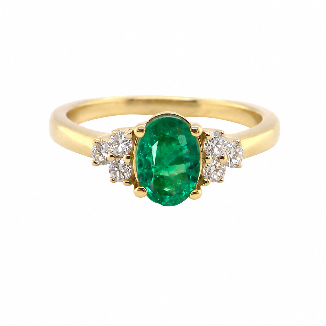 Featuring a lovely deep velvety green emerald centre stone, this 18 carat gold ring is enhanced by six brilliant cut white diamonds.