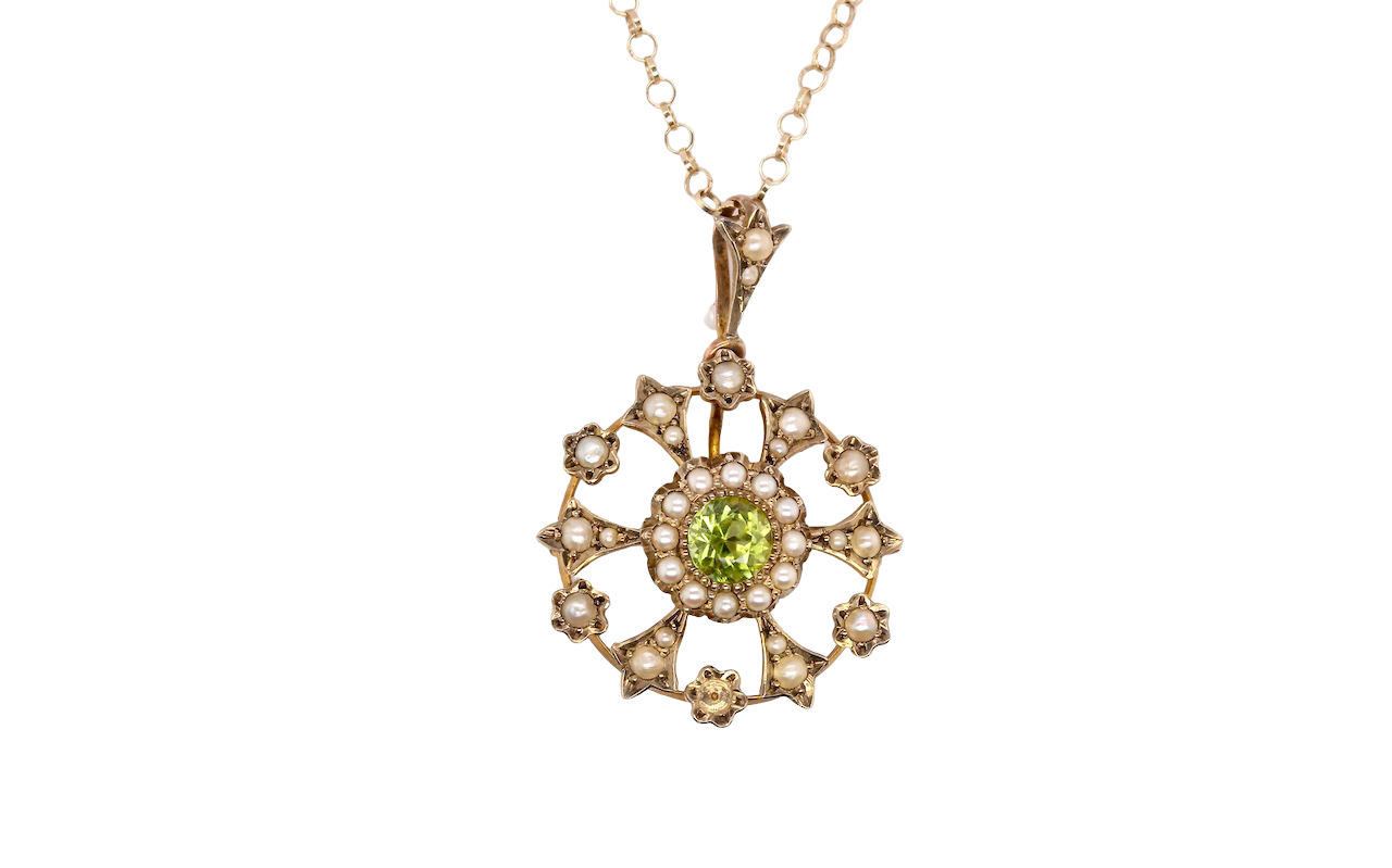 This exquisite piece features a 6mm peridot at its centre, framed by a delicate border of fine seed pearls.
