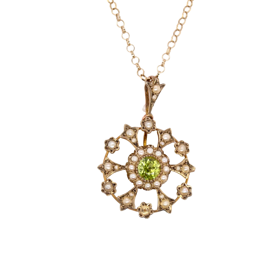 This exquisite piece features a 6mm peridot at its centre, framed by a delicate border of fine seed pearls.