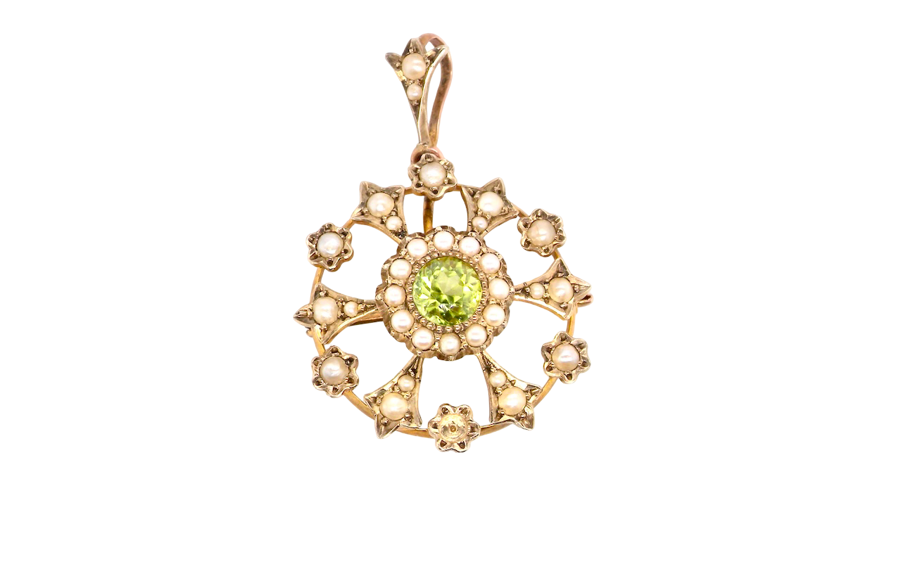 This piece features a 6mm peridot at its centre, framed by a delicate border of fine seed pearls.