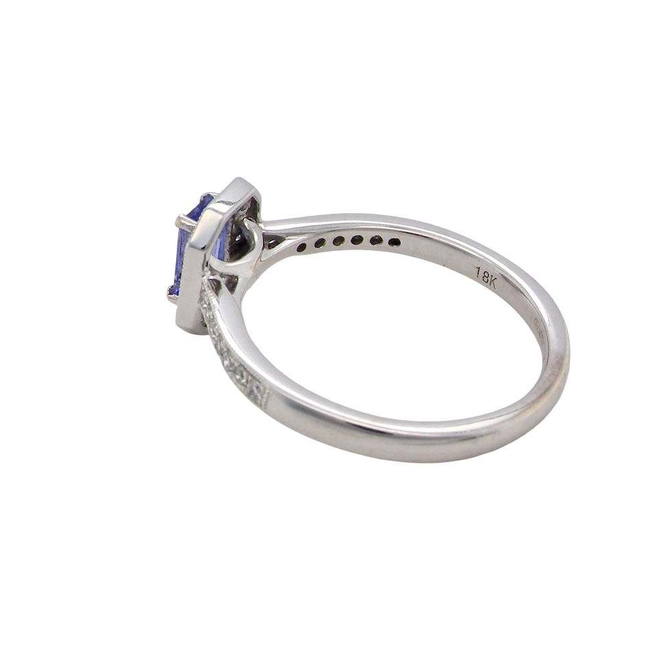 side An elegant cluster ring that features to the centre a rectangular tanzanite gemstone that measures 6x4mm (est 0.50 carats) AAA colour.