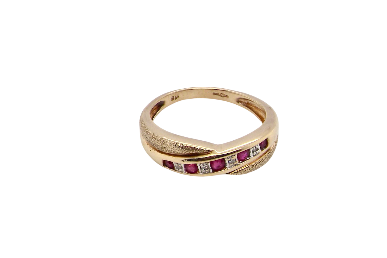 above A 9 carat gold half hoop eternity ring. Set with five calibre cut rubies, from 1.7 to 2mm, and between small 1mm white diamonds.