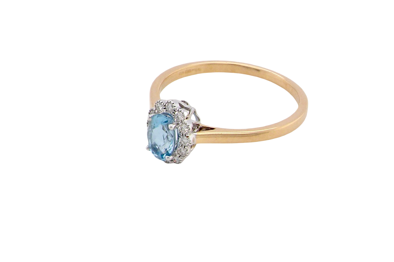 above An 18 carat gold cluster ring. Set to the centre a lovely ice blue aquamarine 6x4mm, claw set.