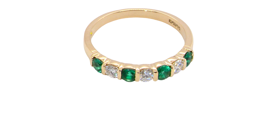 above An 18 carat yellow gold half hoop eternity ring. Set with four bright green emeralds, each 3mm diameter (est each 0.10 carats) .