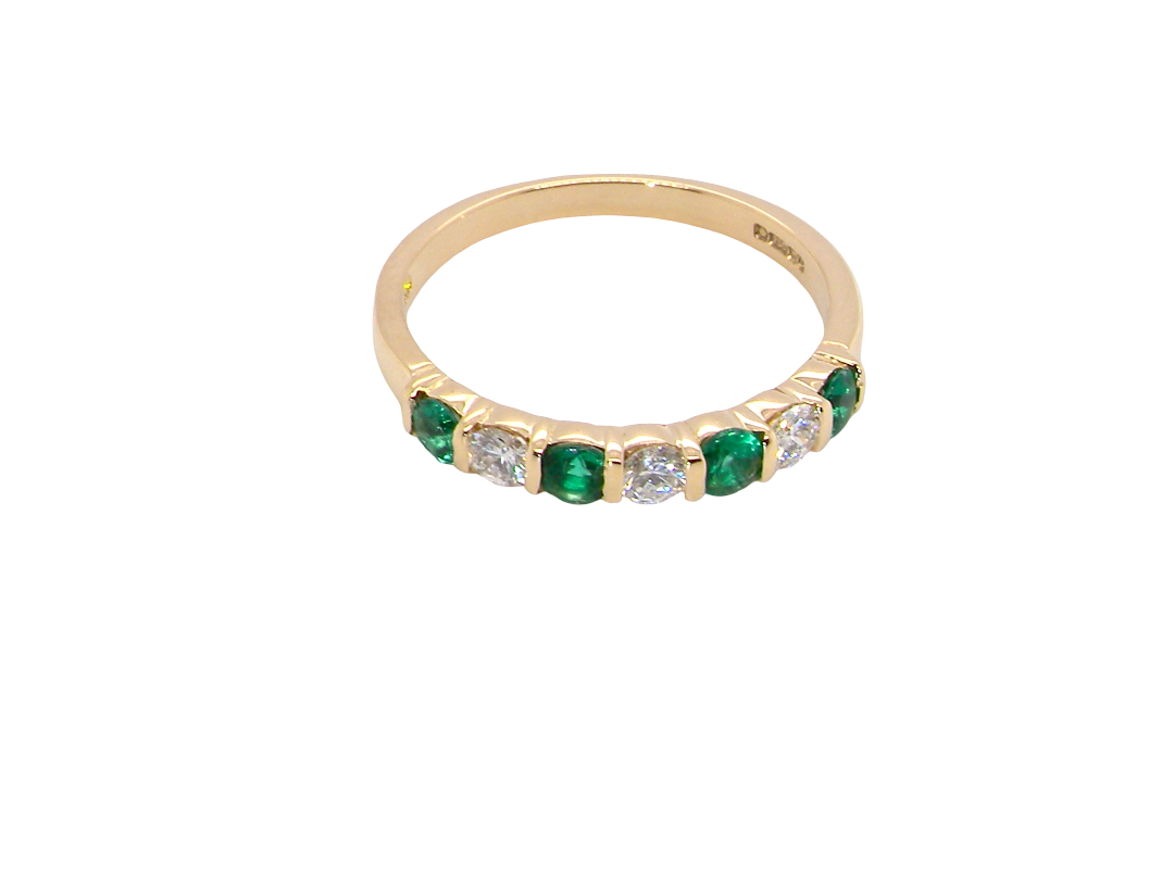above An 18 carat yellow gold half hoop eternity ring. Set with four bright green emeralds, each 3mm diameter (est each 0.10 carats) .