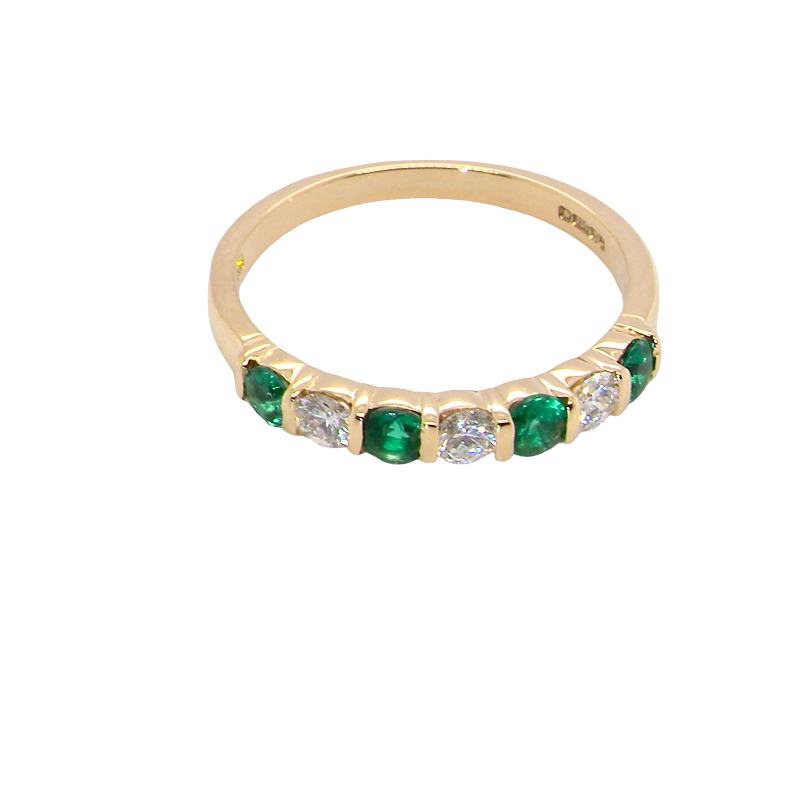 above An 18 carat yellow gold half hoop eternity ring. Set with four bright green emeralds, each 3mm diameter (est each 0.10 carats) .