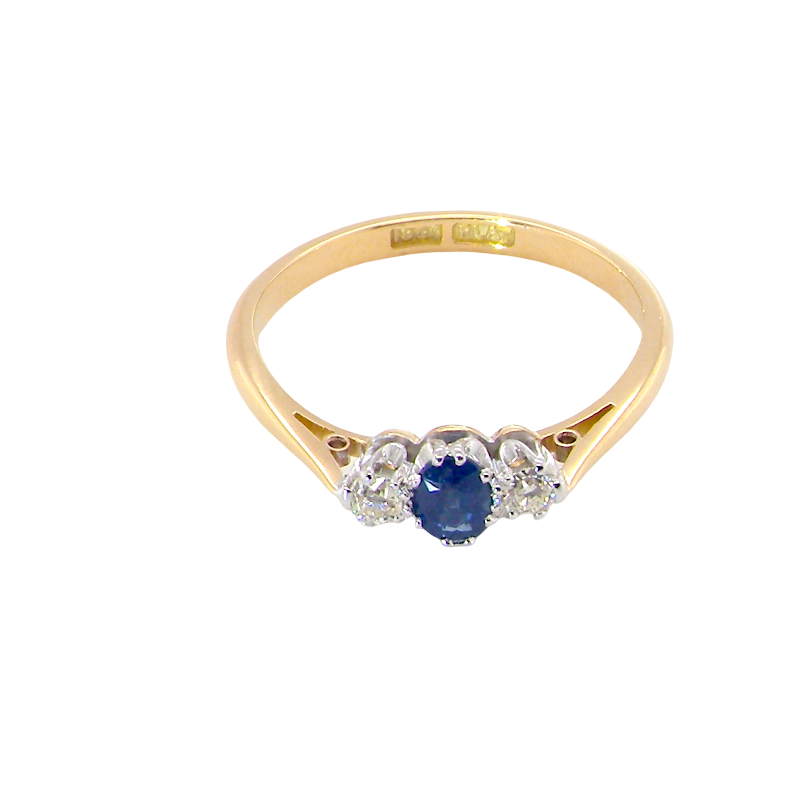 above view The classic trilogy ring, this features to the centre a round mid to dark blue sapphire and each side a brilliant cut white diamond