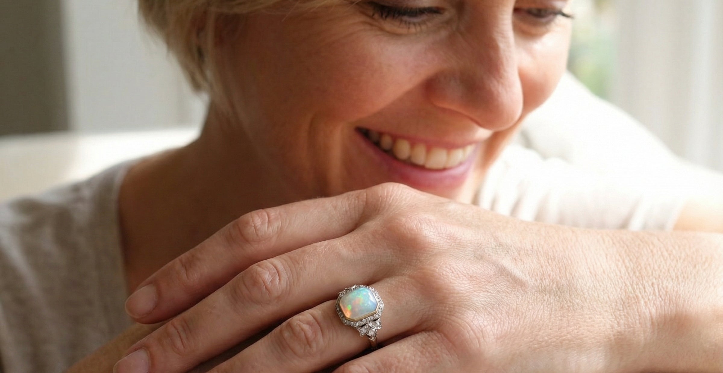 adoring a cabouchon cut opal shown is cushion shaped, measures 15x13 (5.78 carats) displaying a mass of vibrant colours, from flashes of fireglow orange, luminous greens, and lavender purples.