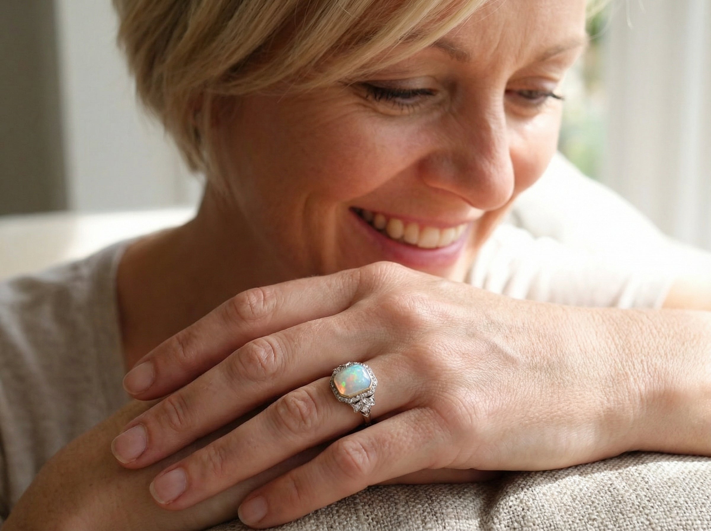 adoring a cabouchon cut opal shown is cushion shaped, measures 15x13 (5.78 carats) displaying a mass of vibrant colours, from flashes of fireglow orange, luminous greens, and lavender purples.