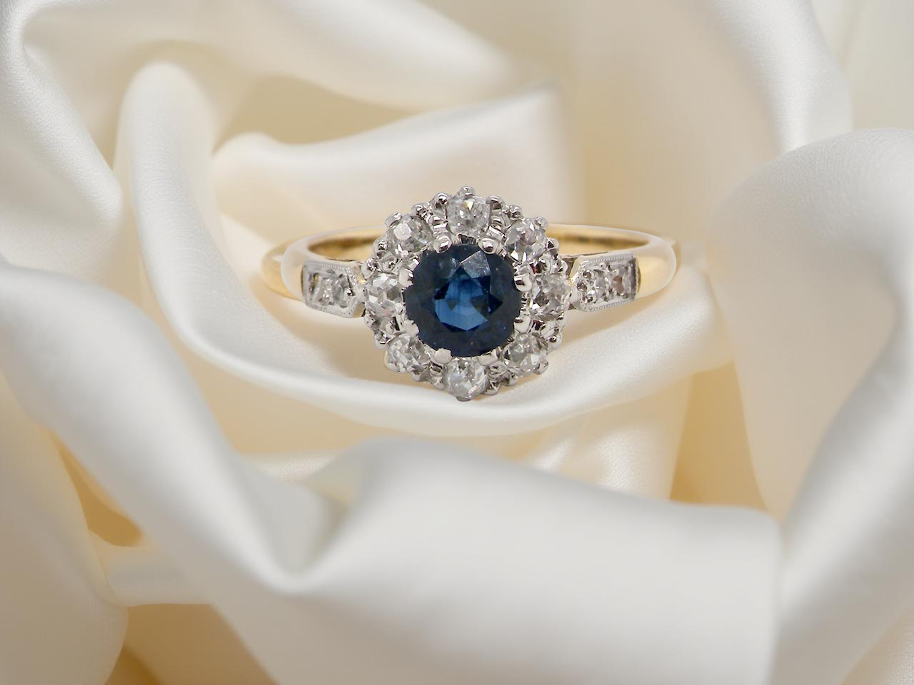 beautiful mid-century cluster ring featuring a round blue sapphire