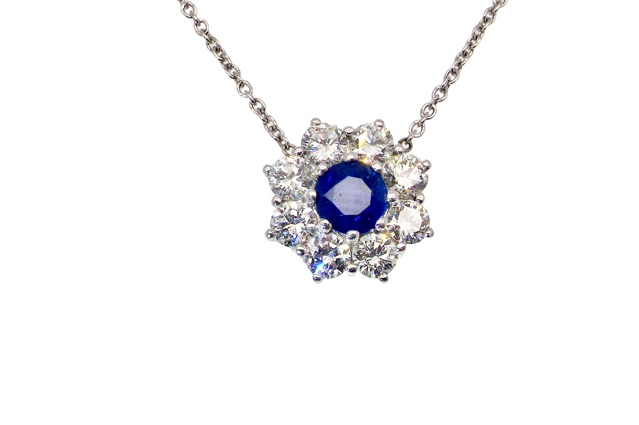 beautiful new 18 carat white gold cluster pendant, showcasing a blue sapphire at its centre.