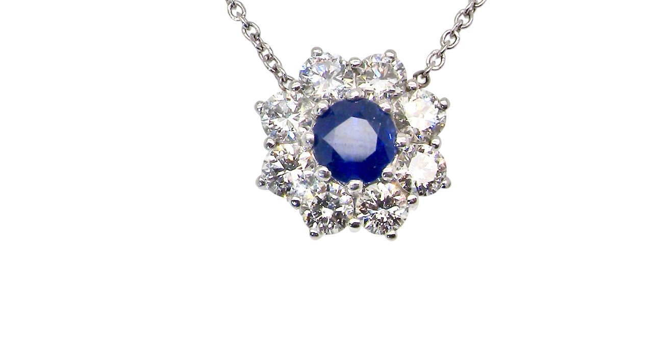 beautiful new 18 carat white gold cluster pendant, showcasing a sapphire at its centre.