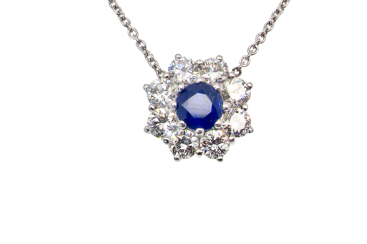 beautiful new 18 carat white gold cluster pendant, showcasing a sapphire at its centre.