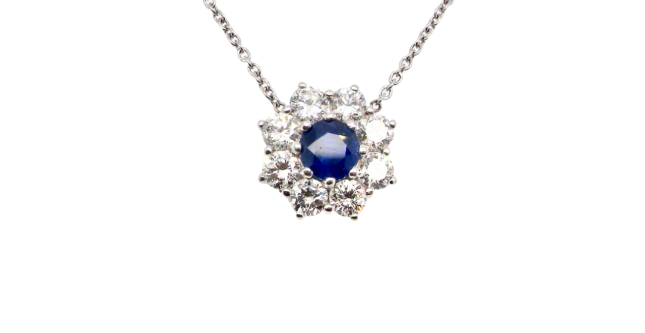 beautiful new 18 carat white gold cluster pendant, showcasing a vibrant blue sapphire at its centre.