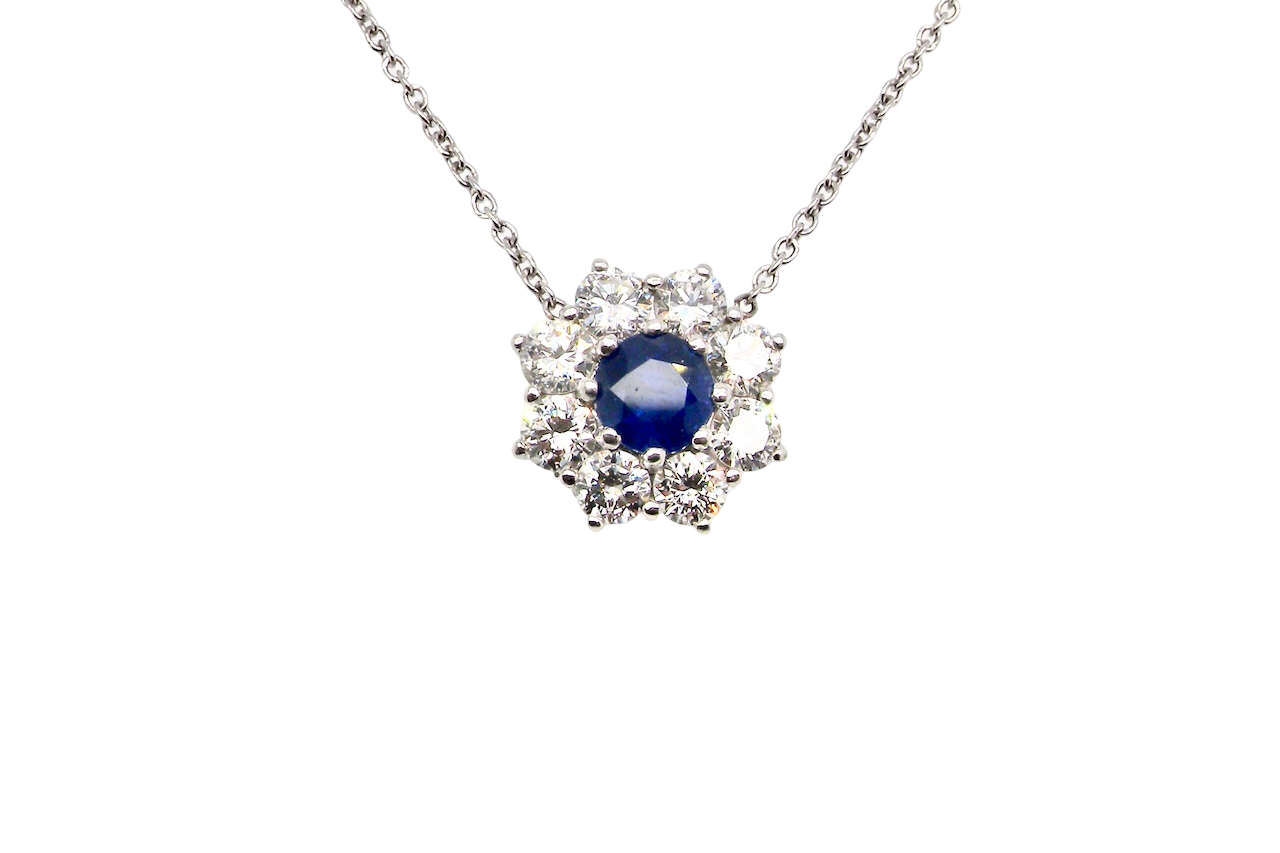 beautiful new 18 carat white gold cluster pendant, showcasing a vibrant blue sapphire at its centre.
