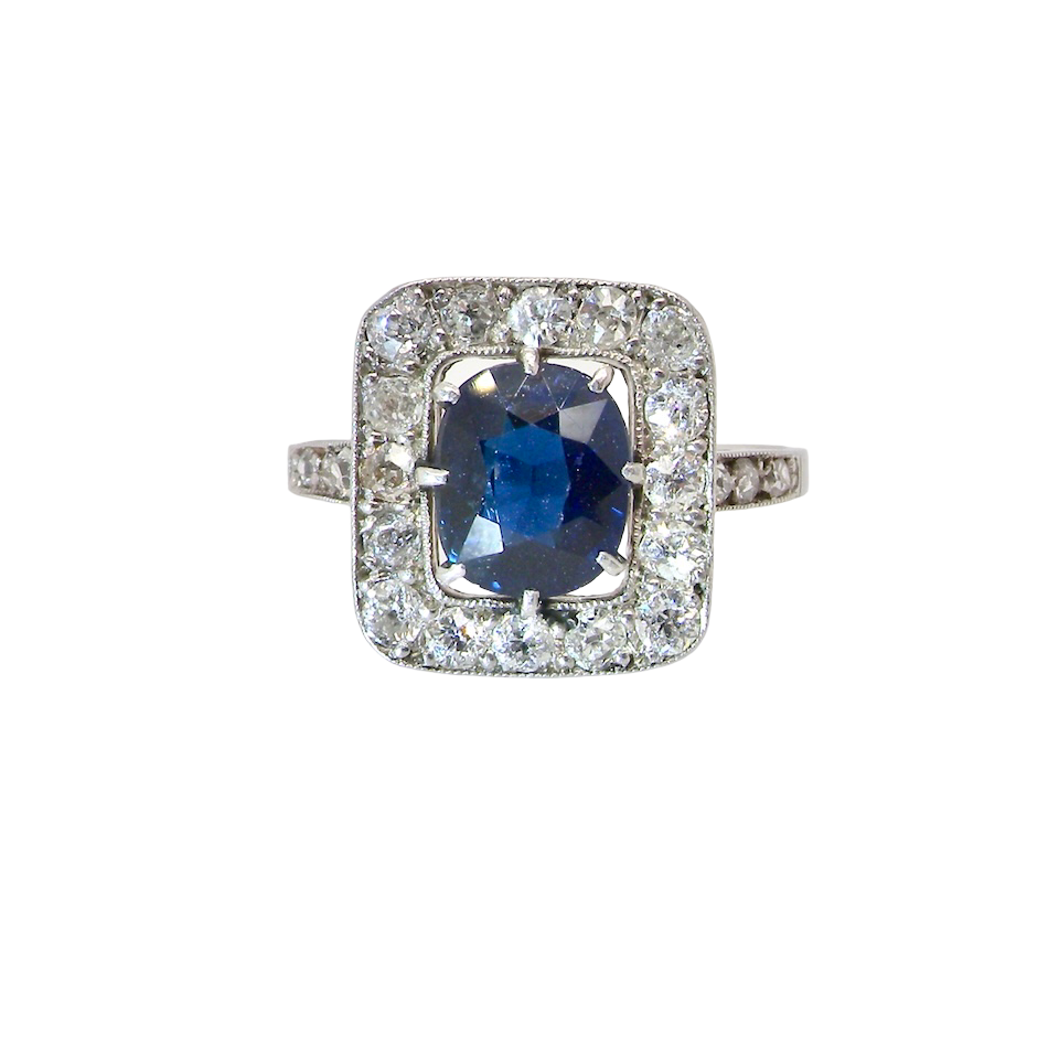 beautiful original Art Deco cluster ring featuring a dark blue oval-cut sapphire