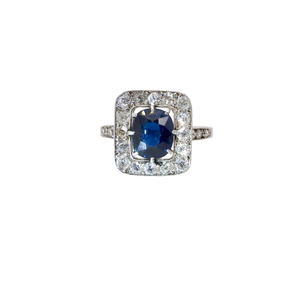 beautiful original Art Deco cluster ring featuring a rich, dark blue oval-cut sapphire