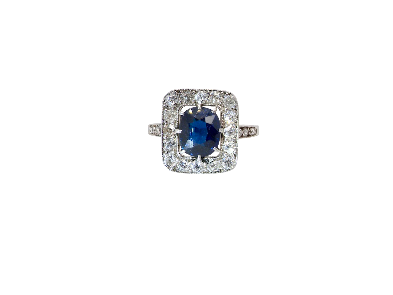 beautiful original Art Deco cluster ring featuring a rich, dark blue oval-cut sapphire